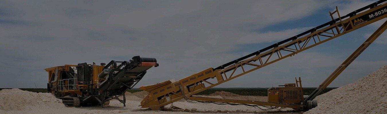 Large Crusher service equipment in a dirt field.