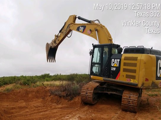 Large yellow Cat branded caterpillar machine about to dig in the dirt.